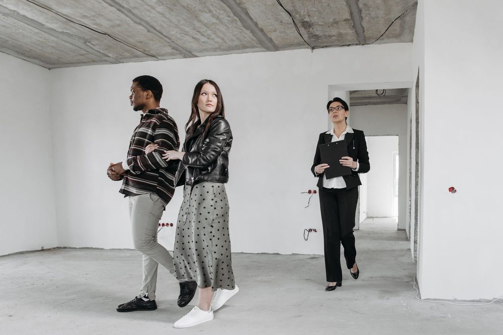 Three people walking through an empty house together