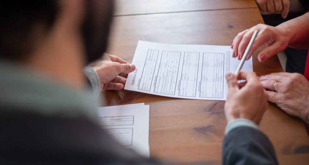 Two people going through paperwork at a table